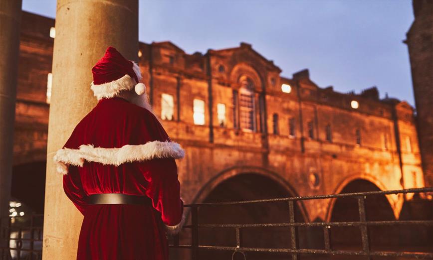 Bath at Christmas - Father Christmas looking at Pulteney Bridge