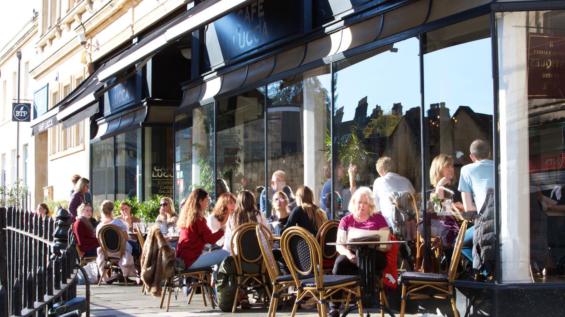 People sitting outside Cafe Lucca in Bath in the sunshine