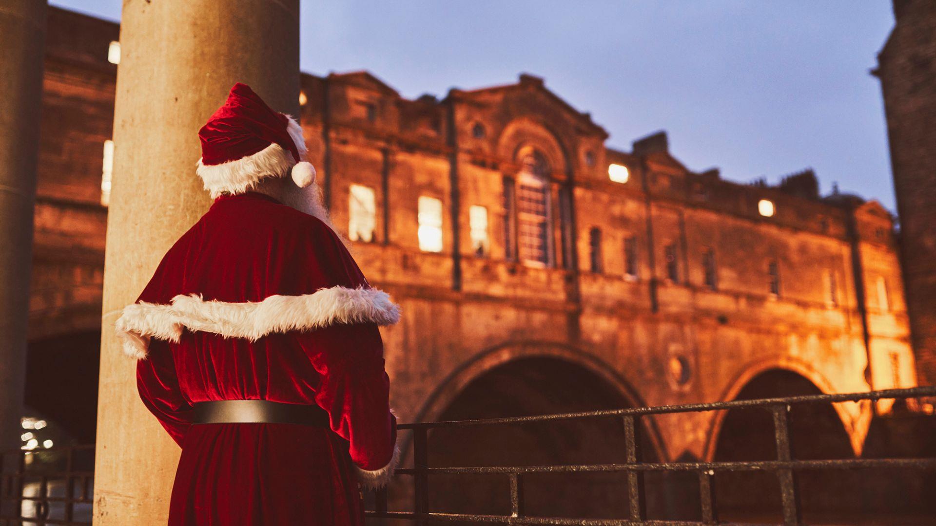 Father Christmas looking at Pulteney Bridge - Bath at Christmas