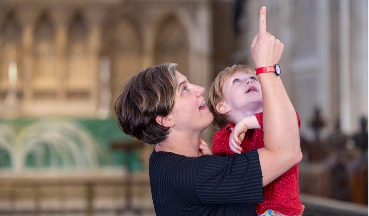 Woman holding a child pointing up