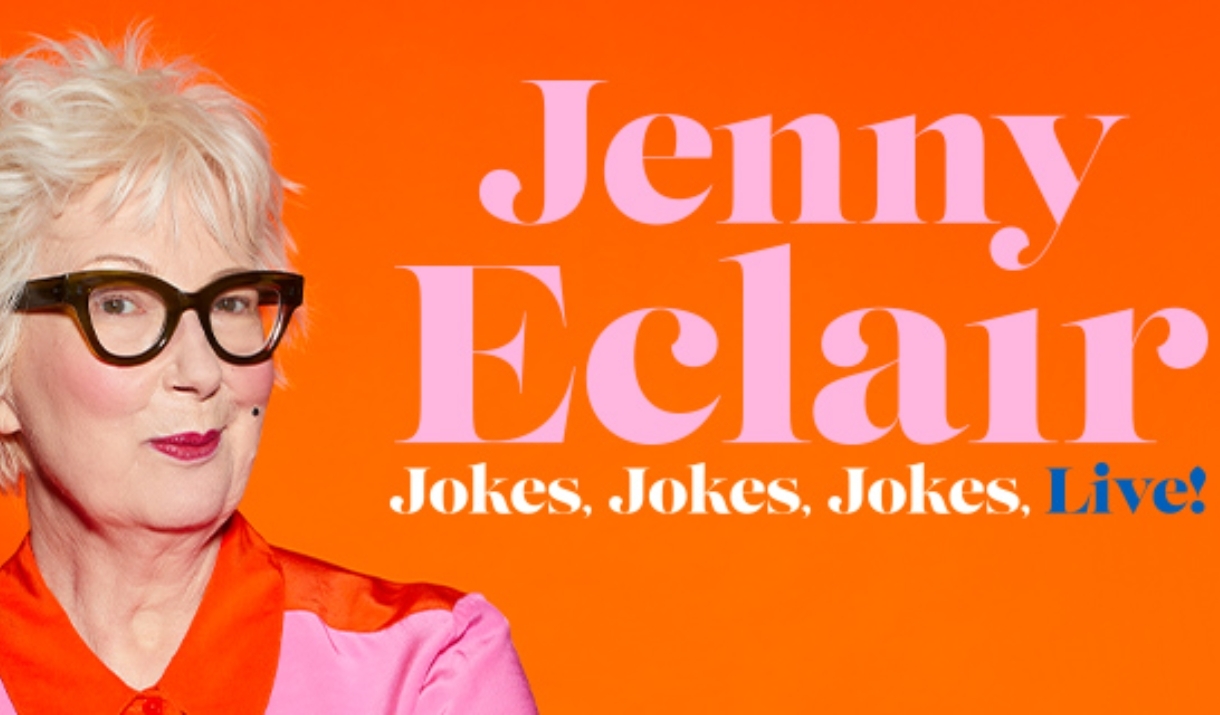 Jenny Eclair in a pink shirt, standing in front of a orange background.