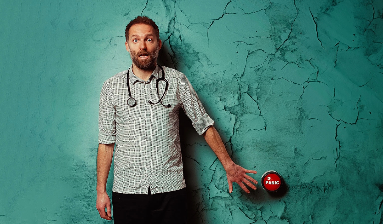 Benj Waterhouse wearing a stethoscope and pressing a panic button