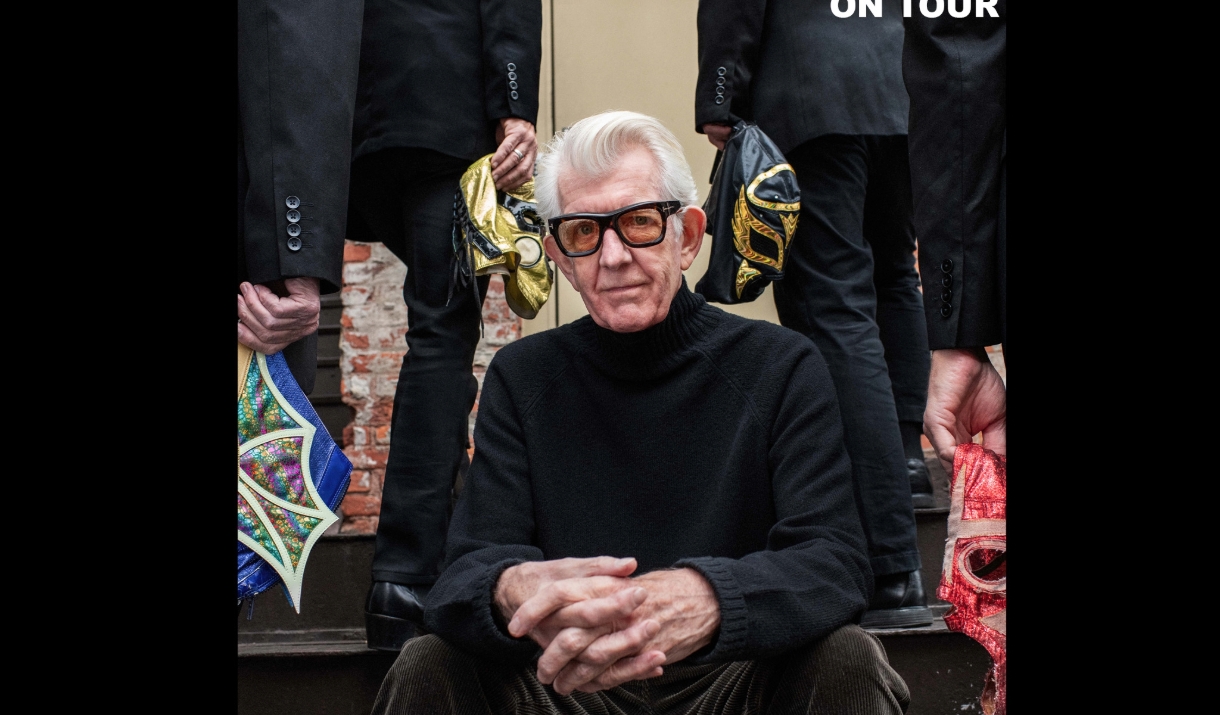 Nick Lowe sitting on a step, looking direct to camera