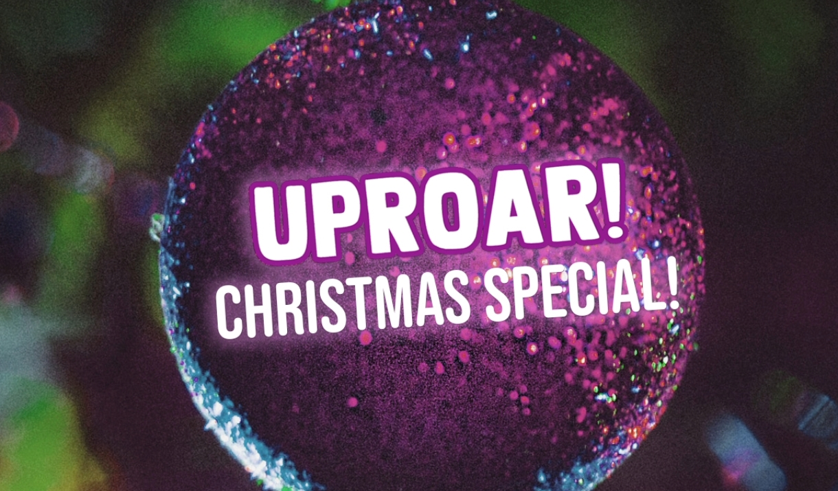 A purple Christmas ornament with the Uproar! logo