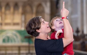 Woman holding a child pointing up