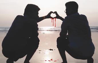 Two brothers making a 'hand heart' which is dripping blood