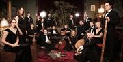 Members of an orchestra posing in a lounge with their instruments