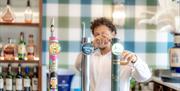 Image of person pouring a pint behind the bar