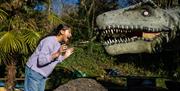 Child shouting at dinosaur animatronic