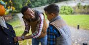 Man and boy looking at scarecrow